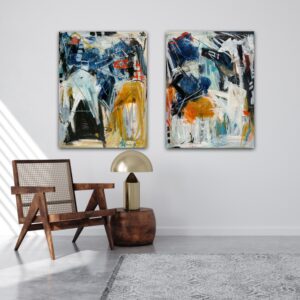 Sæt af to malerier i klare farver hænger side om side over stol og bordlampe i lys stue