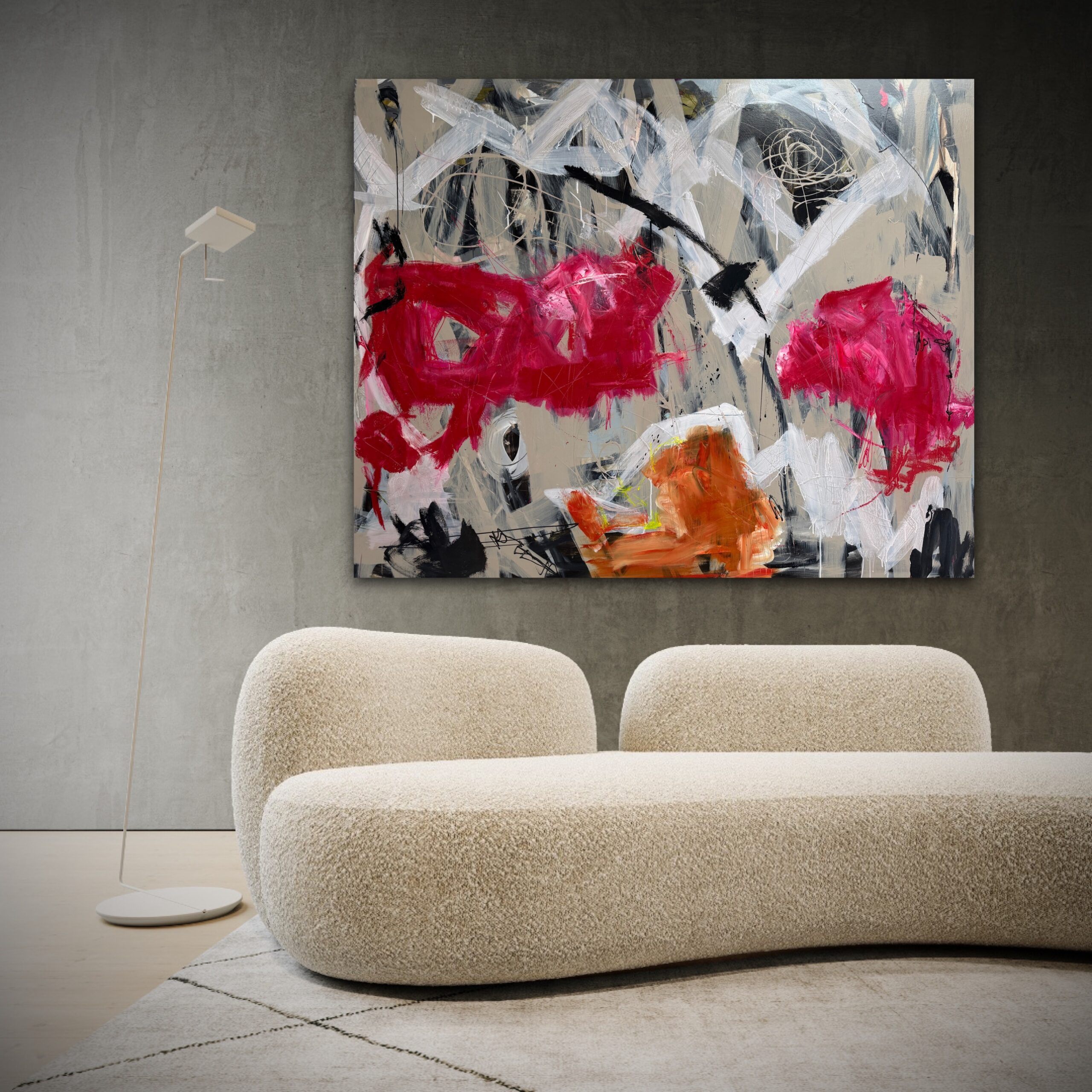 Abstrakt kunstværk i pink, orange og sort hænger på betonvæg i moderne lounge med blød sofa